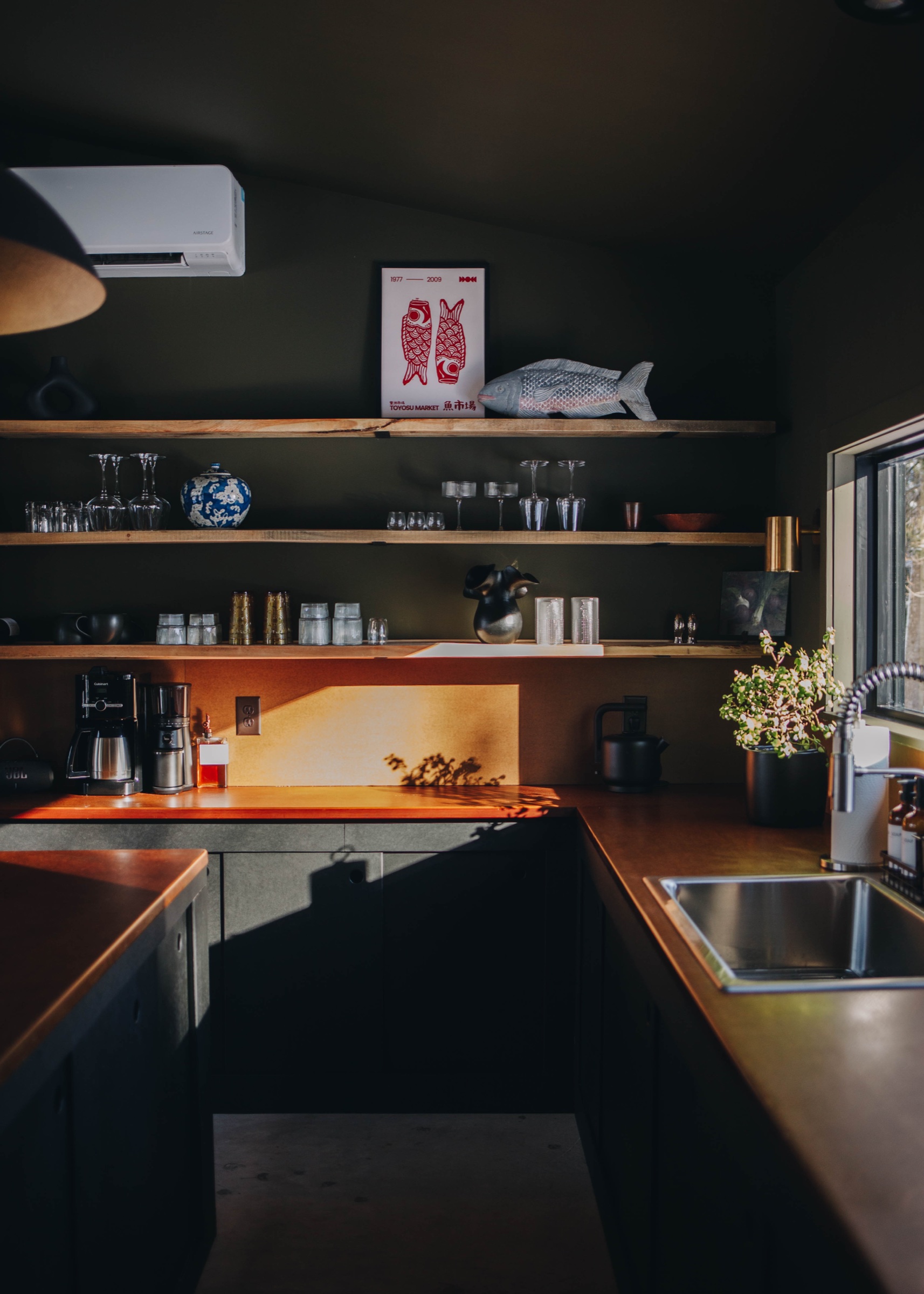 Kitchen with open shelving, coffee setup, and natural light