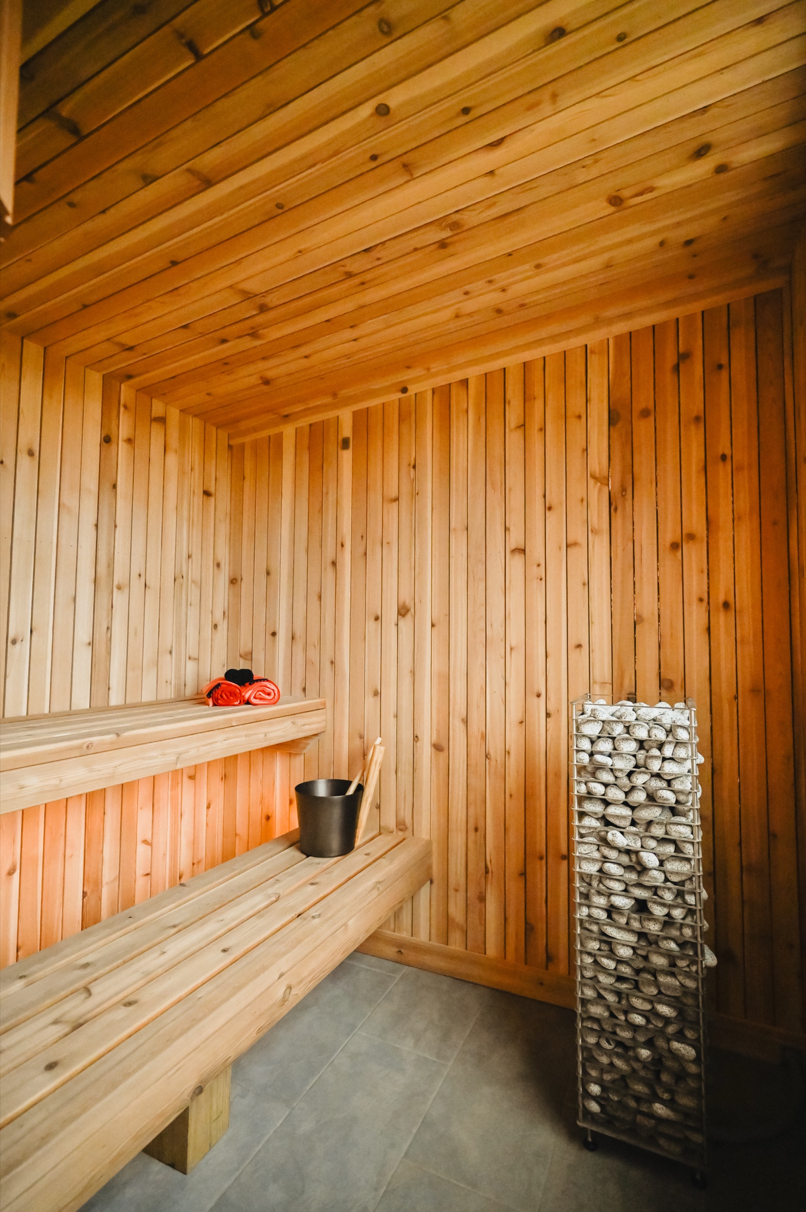 Cedar-lined IKI sauna interior with stone heater and wilderness window